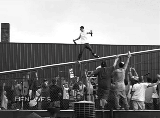 Ben Weis front side above crowd hold a bottle of booze in each hand