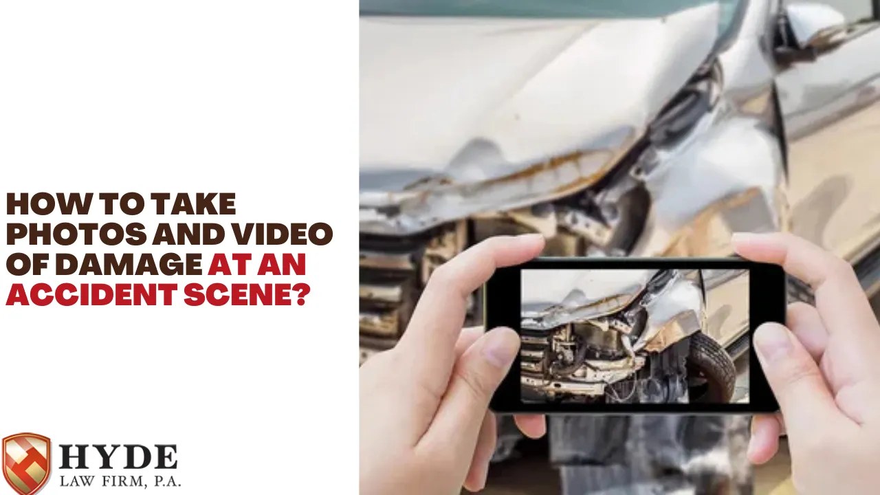 Hands holding a smartphone documenting vehicle damage after a roadway crash