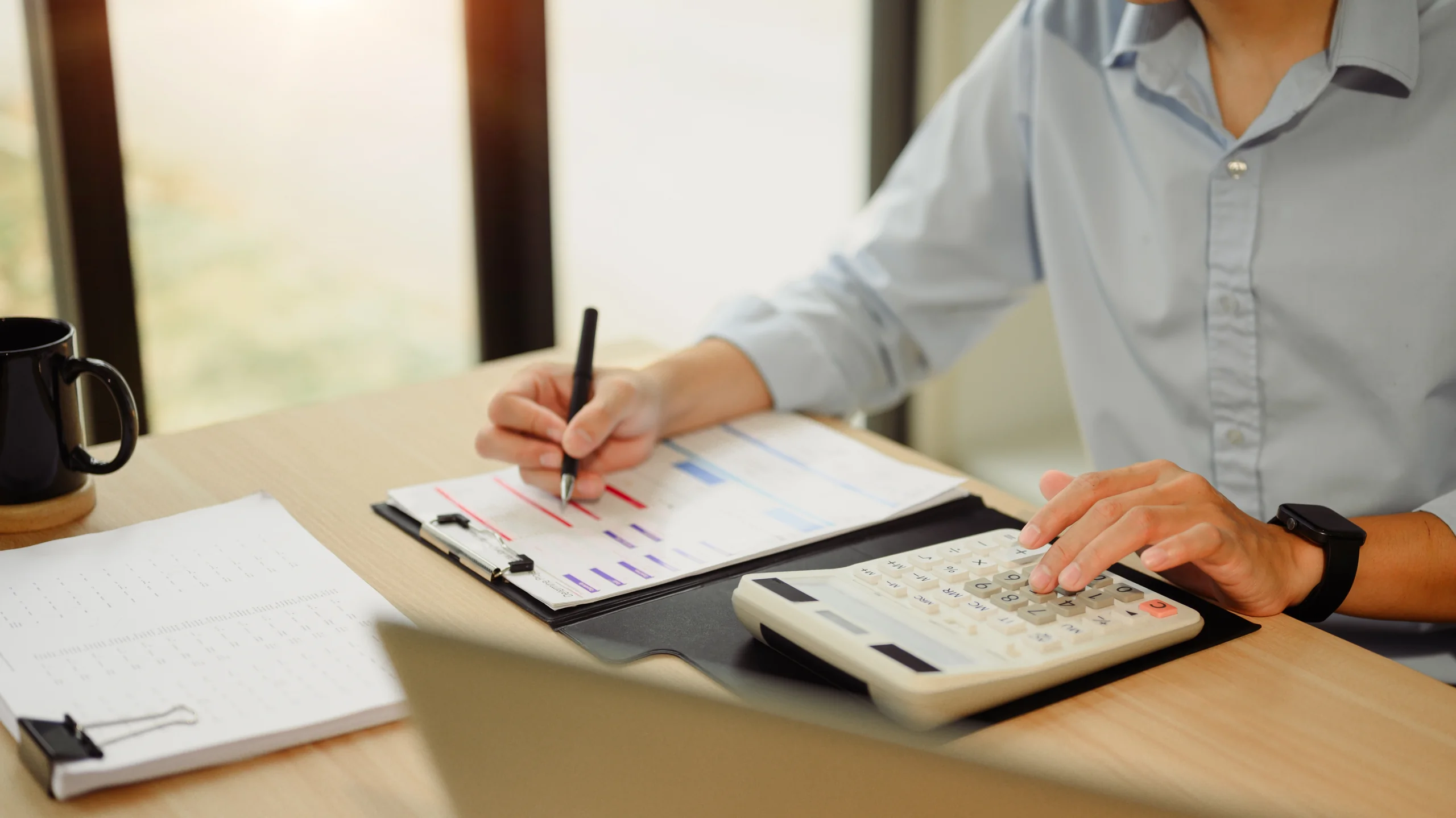 Professional reviewing documents and calculations for tax analysis