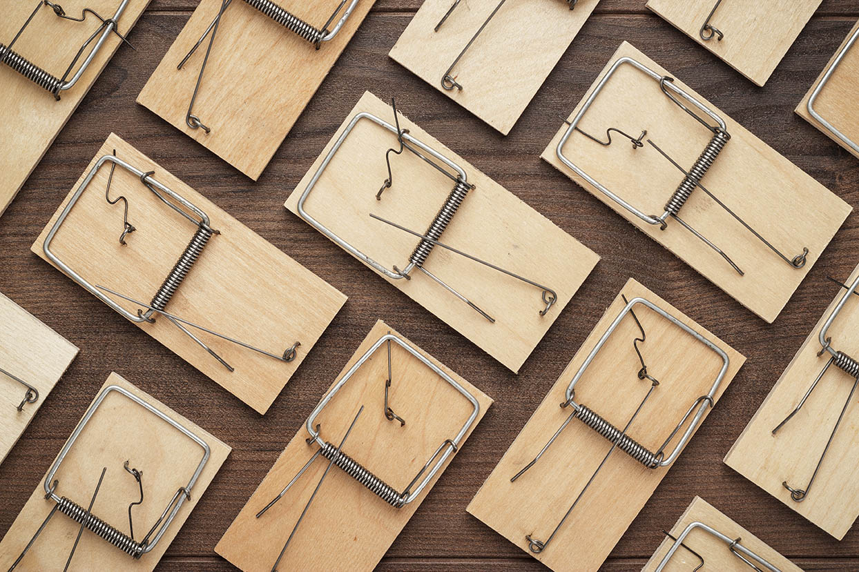 many mousetraps on the wooden background